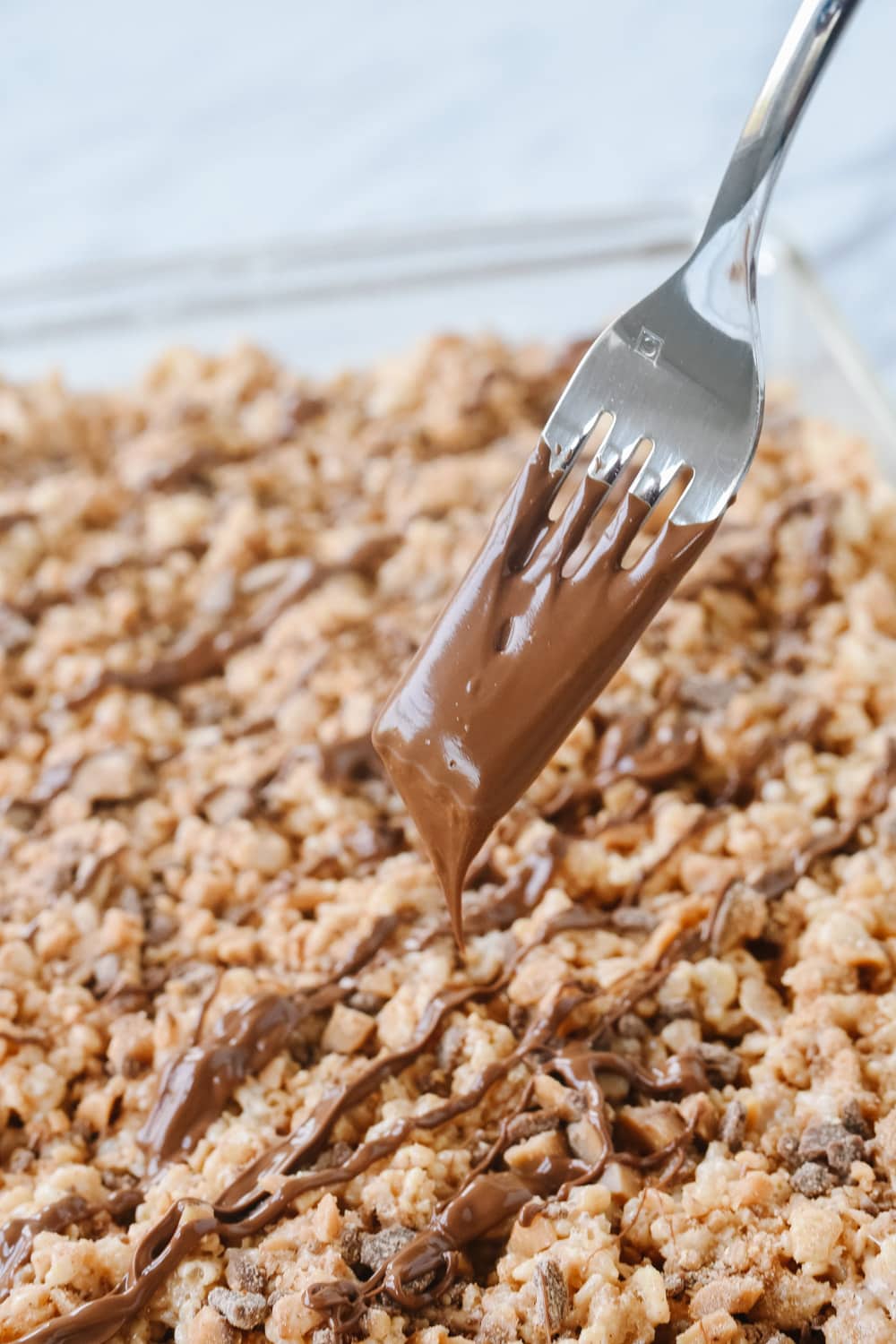 drizzling chocolate over rice krispie treats