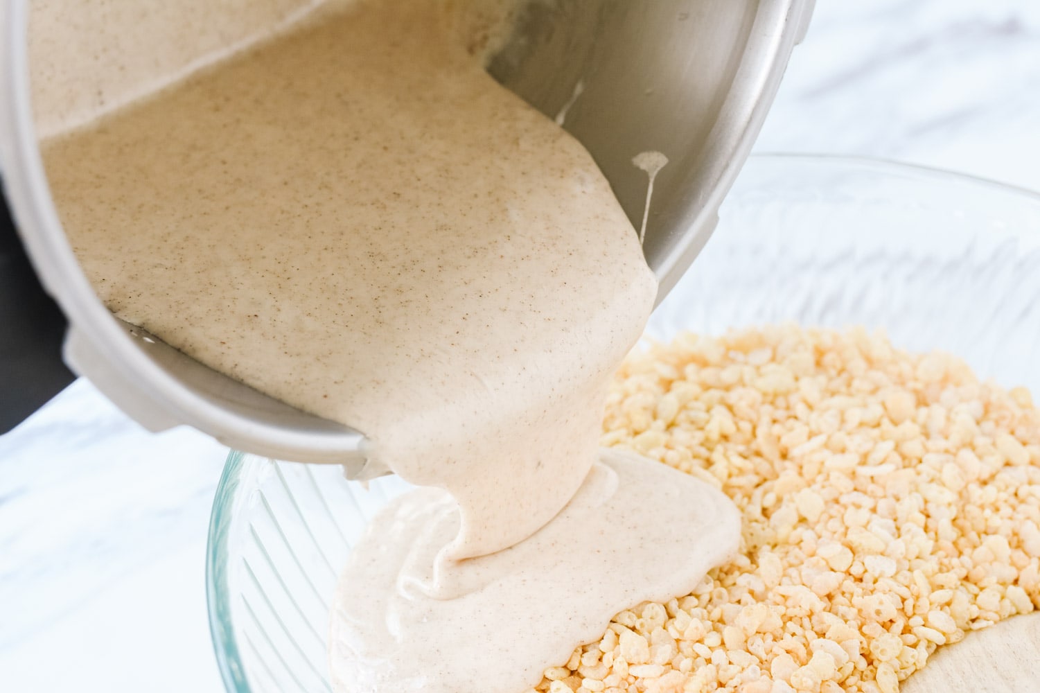 Pouring marshmallow over cinnamon rice krispie treats
