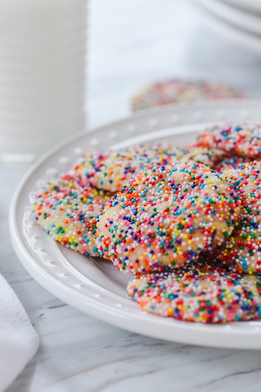 plate of sugar cookies with sprinkles and a glass of milk