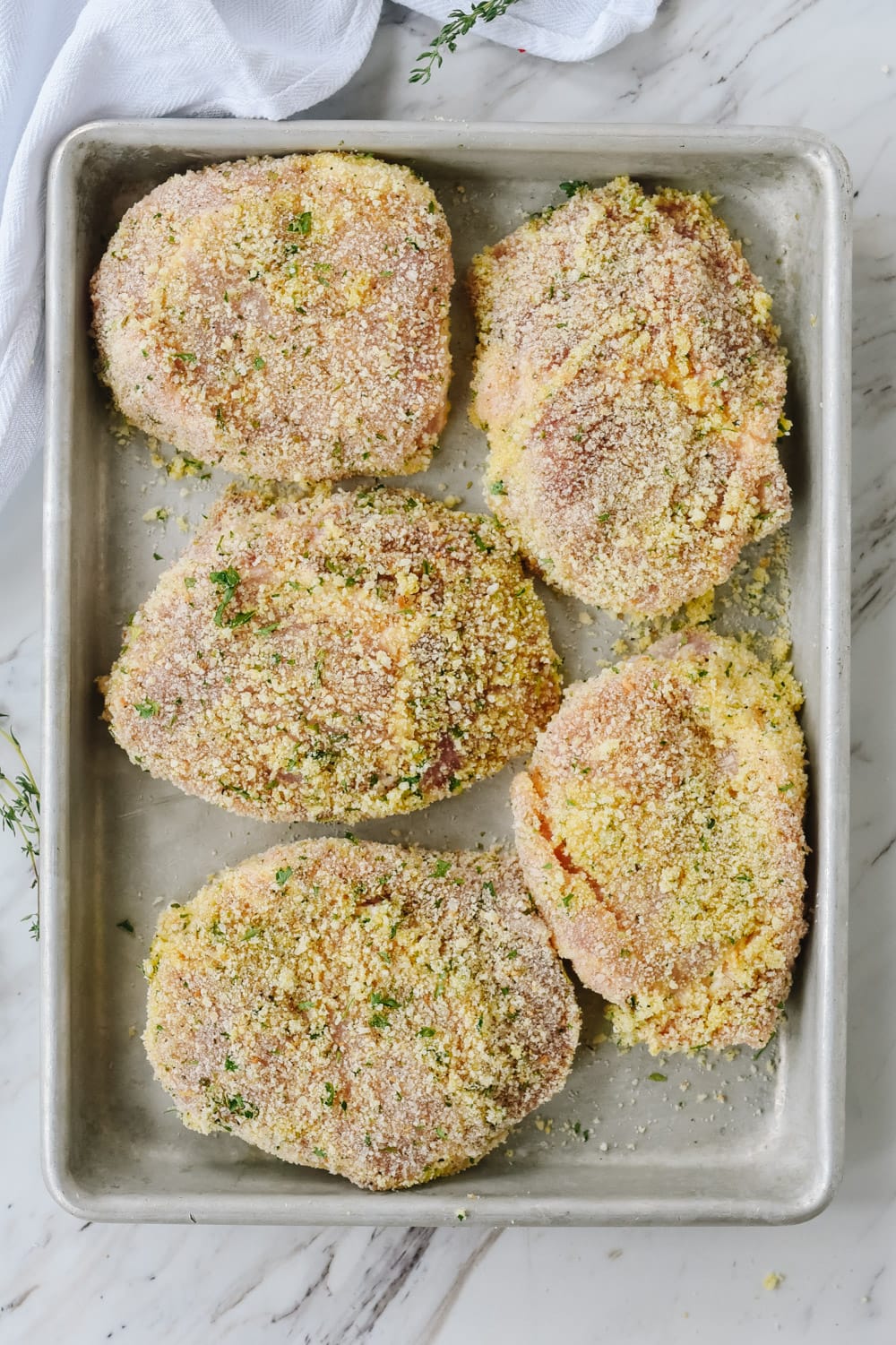 breaded pork chops on baking sheet