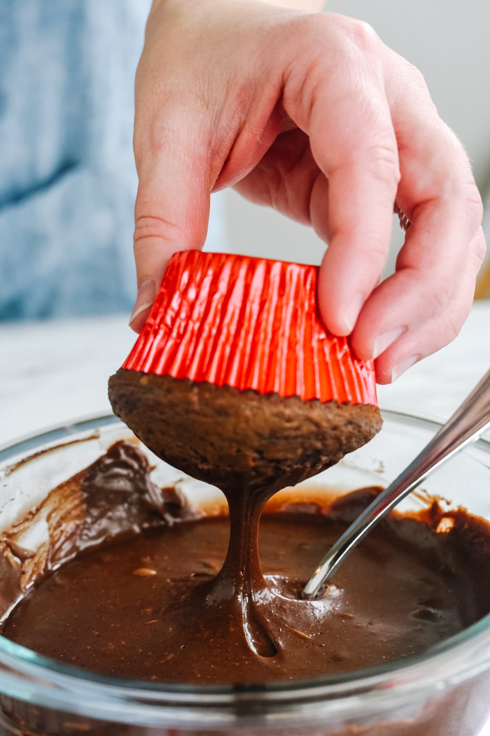 dipping cupcake into chocolate ganache