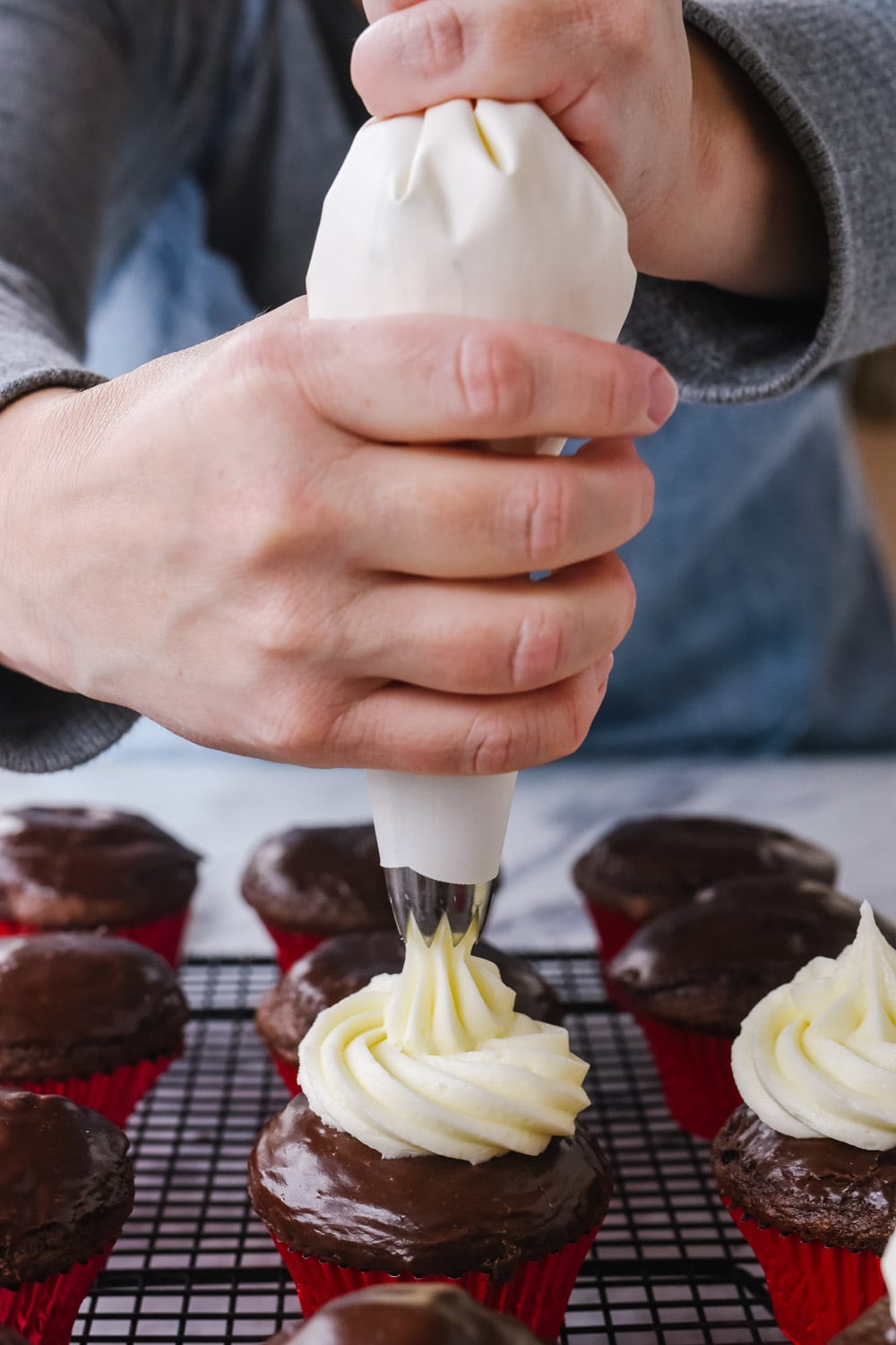 frosting a chocolate cupcake