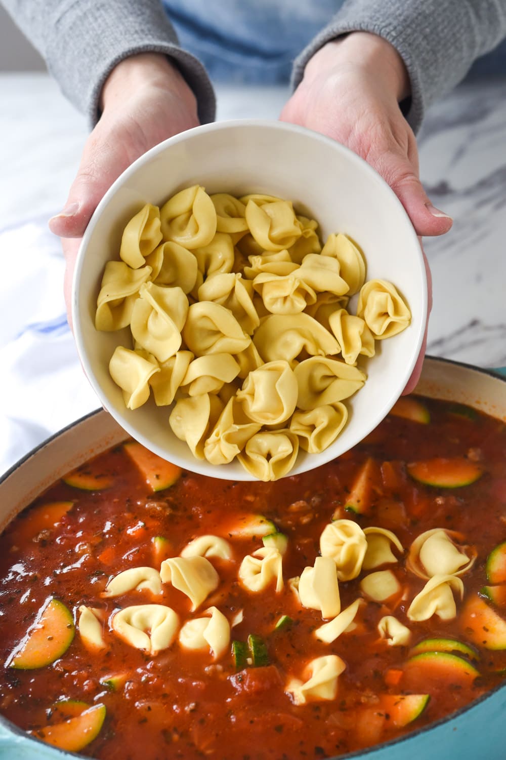 adding tortellini to sausage tortellini soup