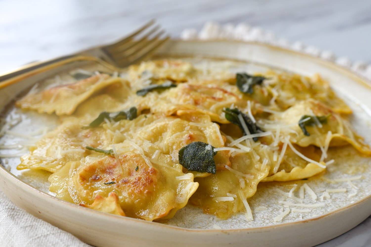 Brown butter ravioli on a plate with cheese