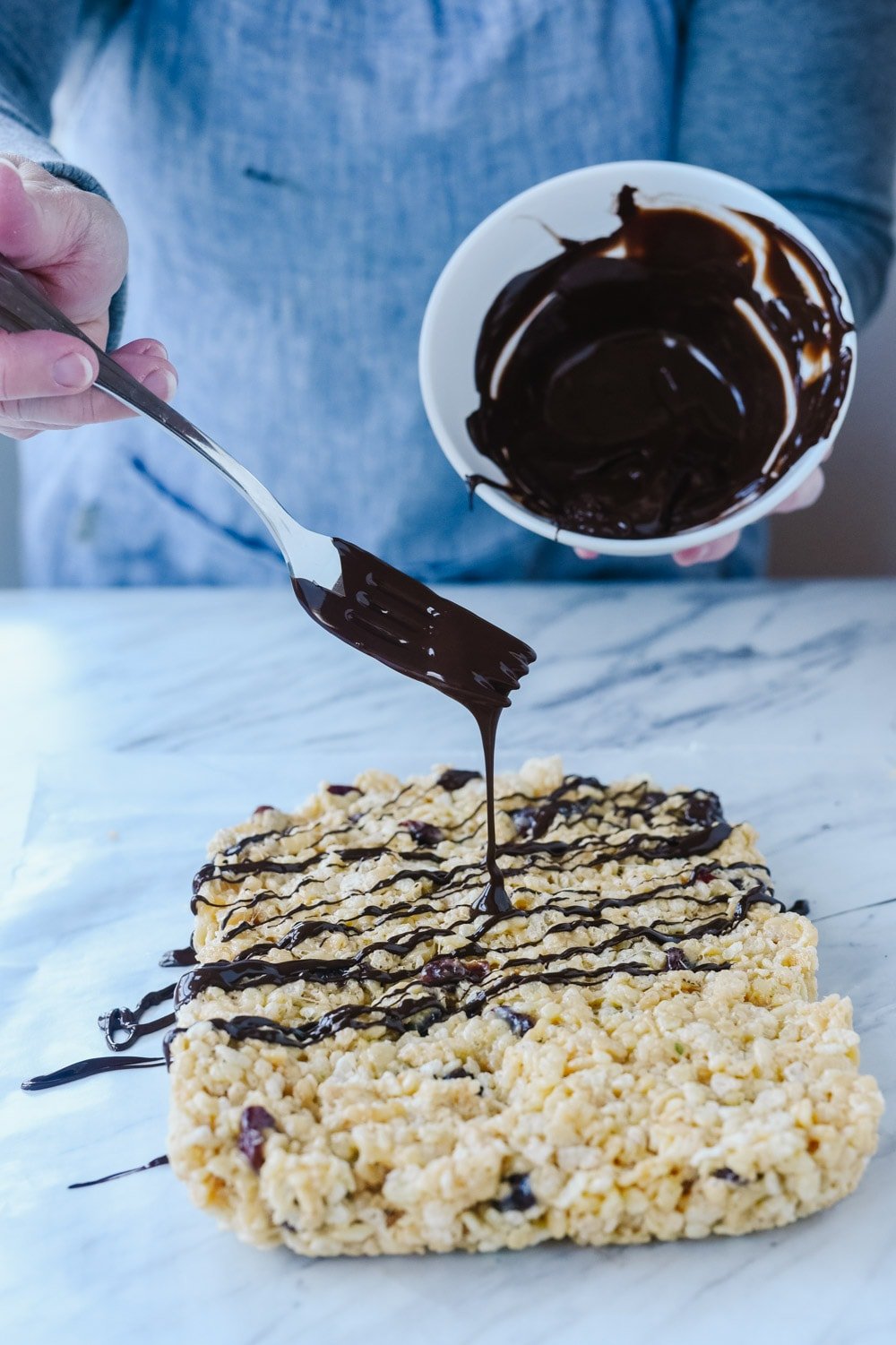 drizzling chocolate over chocolate cherry rice krispie treats