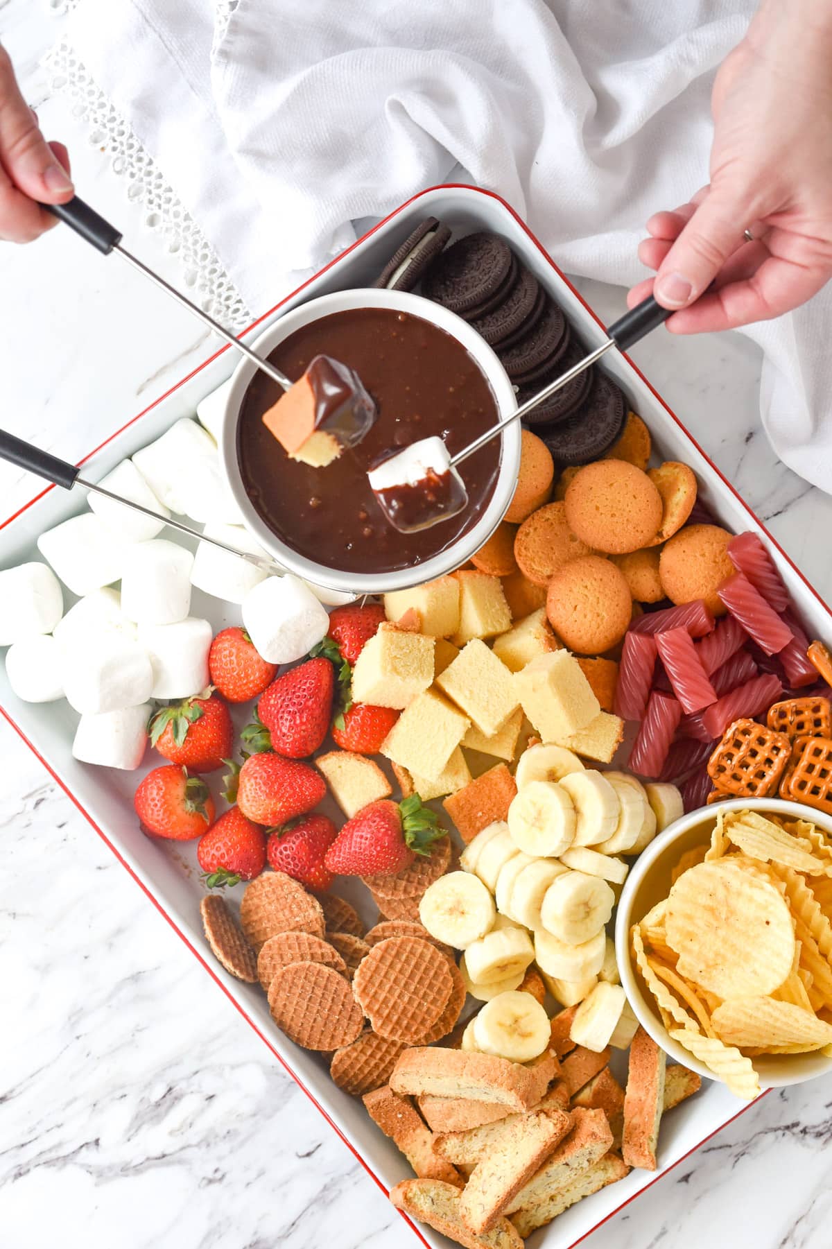 two hands dipping into chocolate fondue