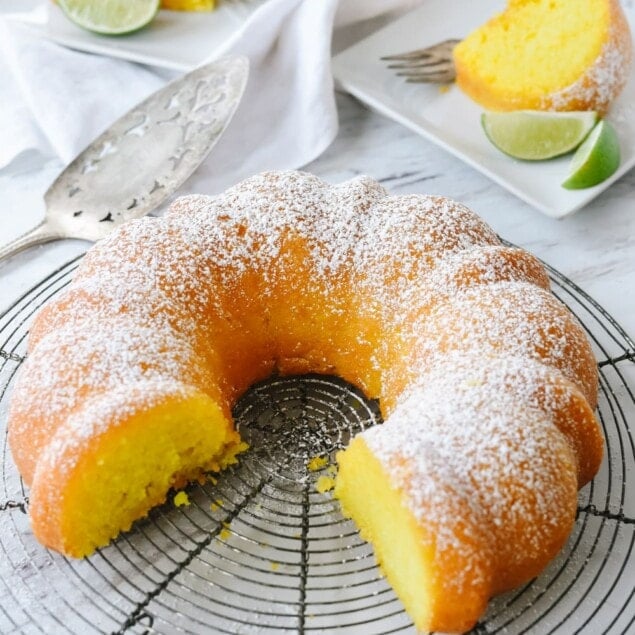 key lime cake with two pieces cut out of it