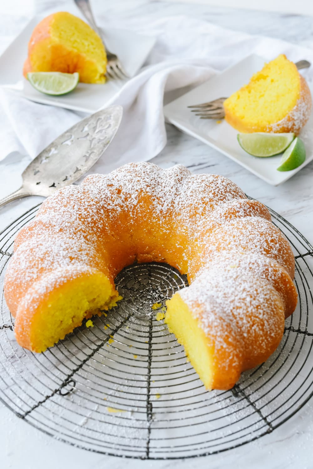 key lime cake with two pieces cut out of it