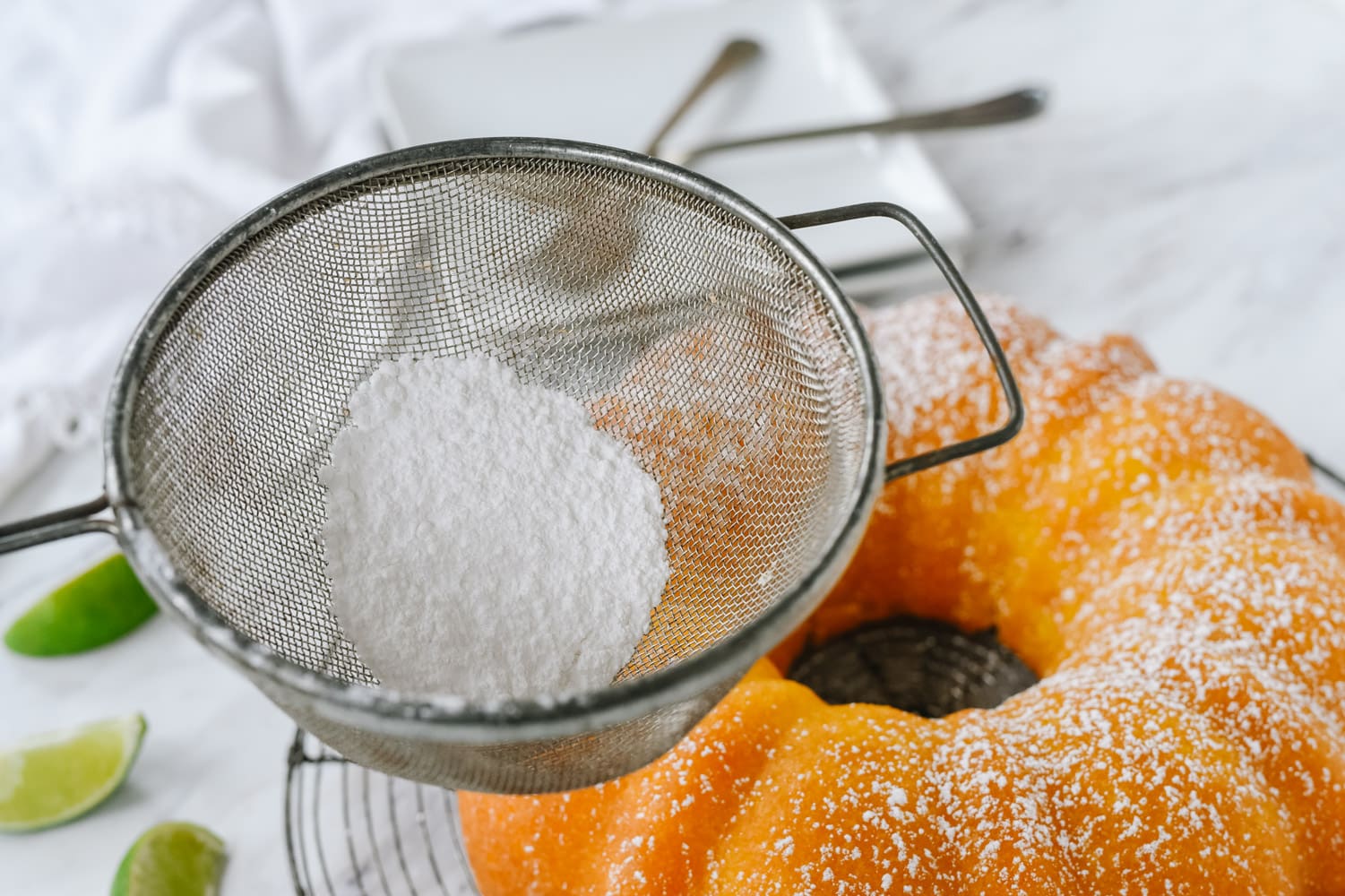 garnishing key lime cake with powdered sugar