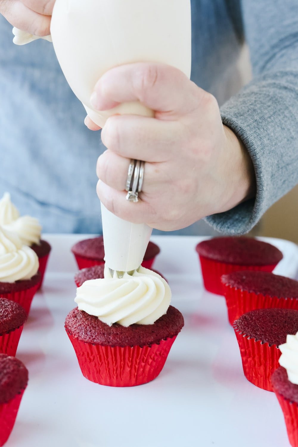 frosting a red velvet cupcake