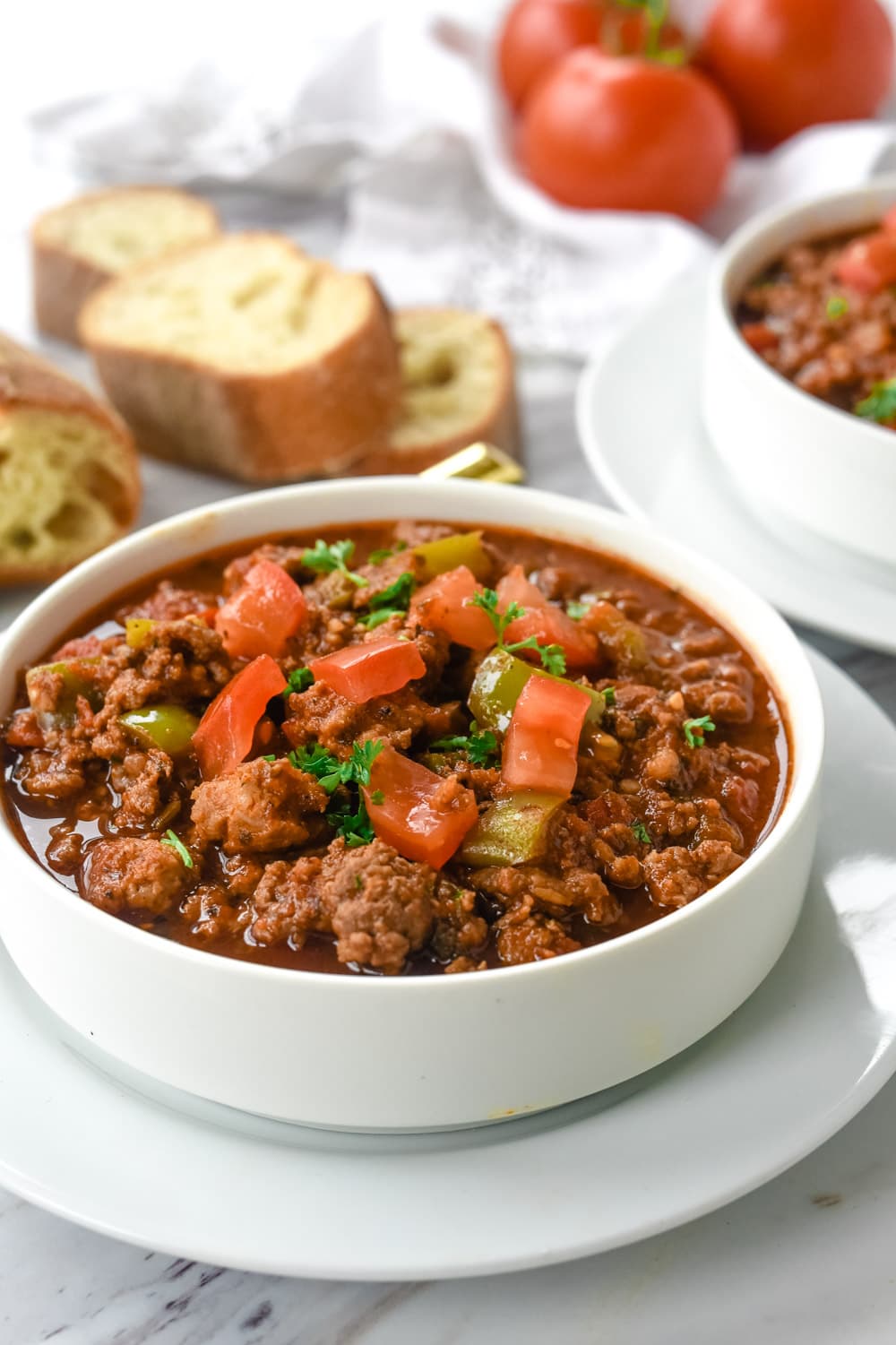 bowl of chili with tomatoes on top
