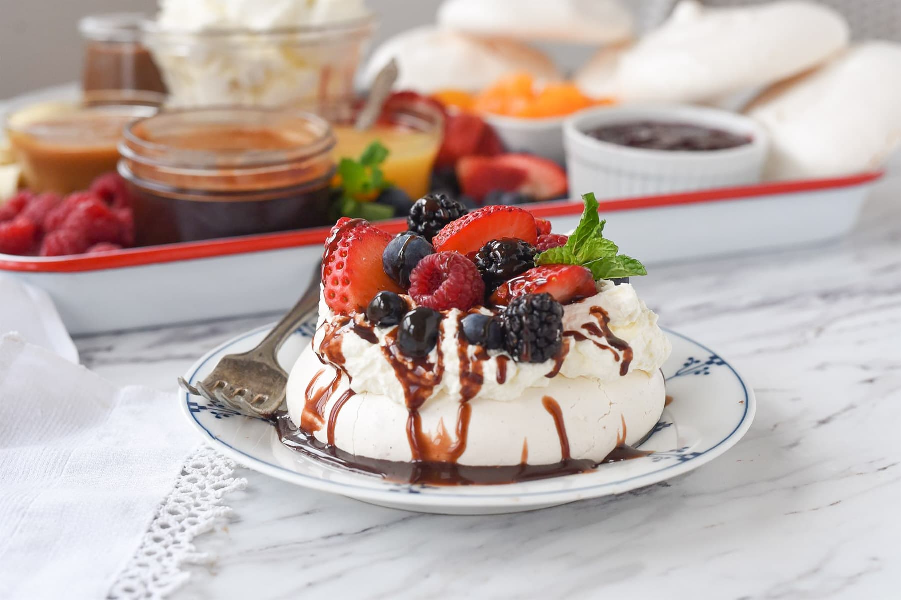 pavlova on a plate in front of dessert board