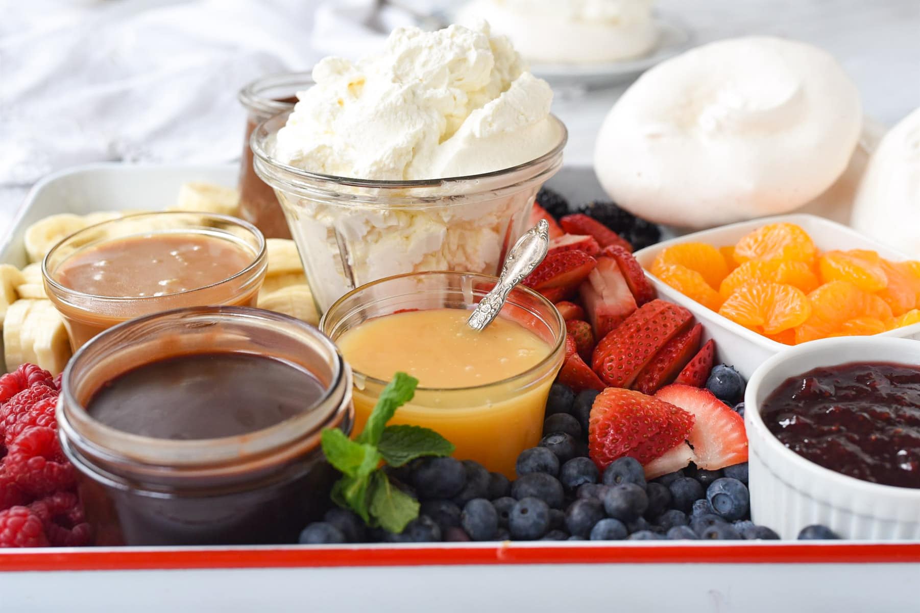 whipped cream on pavlova dessert board