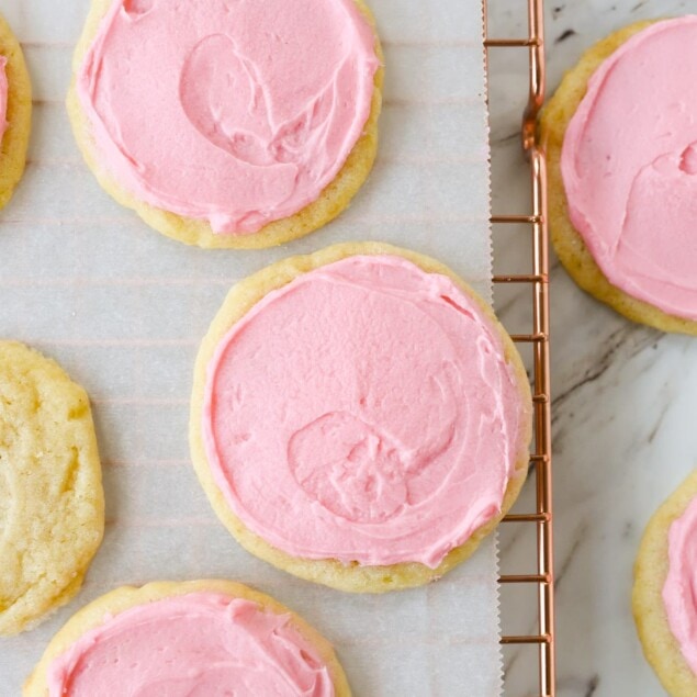 pink frosted sugar cookies on a cooling rack