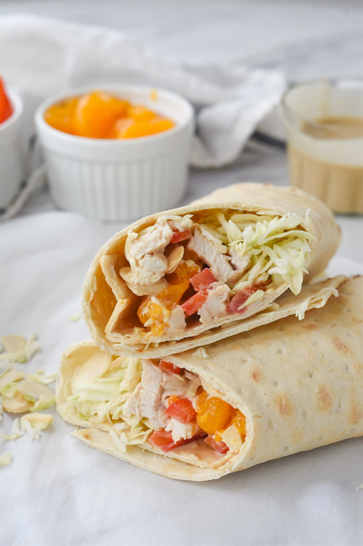 A wrap with chicken and red peppers cut in half