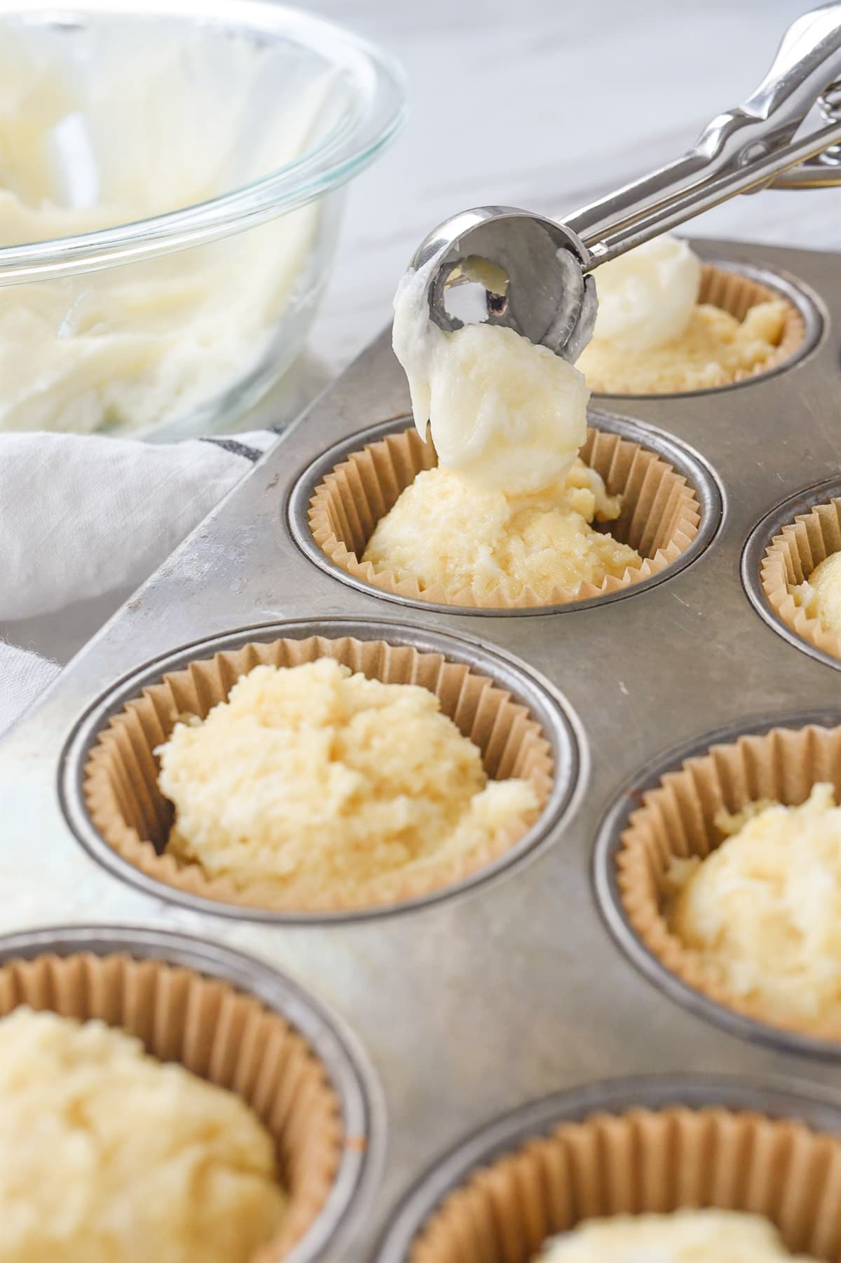 scoops of cream cheese filling on muffins