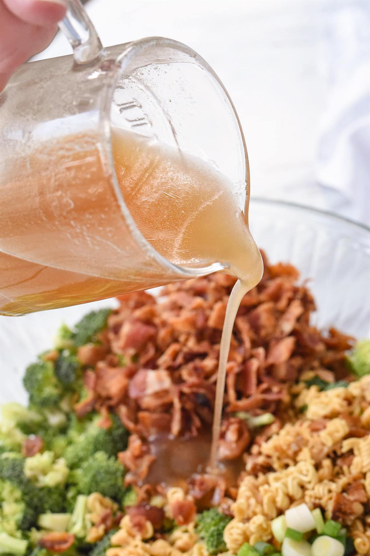 pouring dressing on the broccoli crunch salad