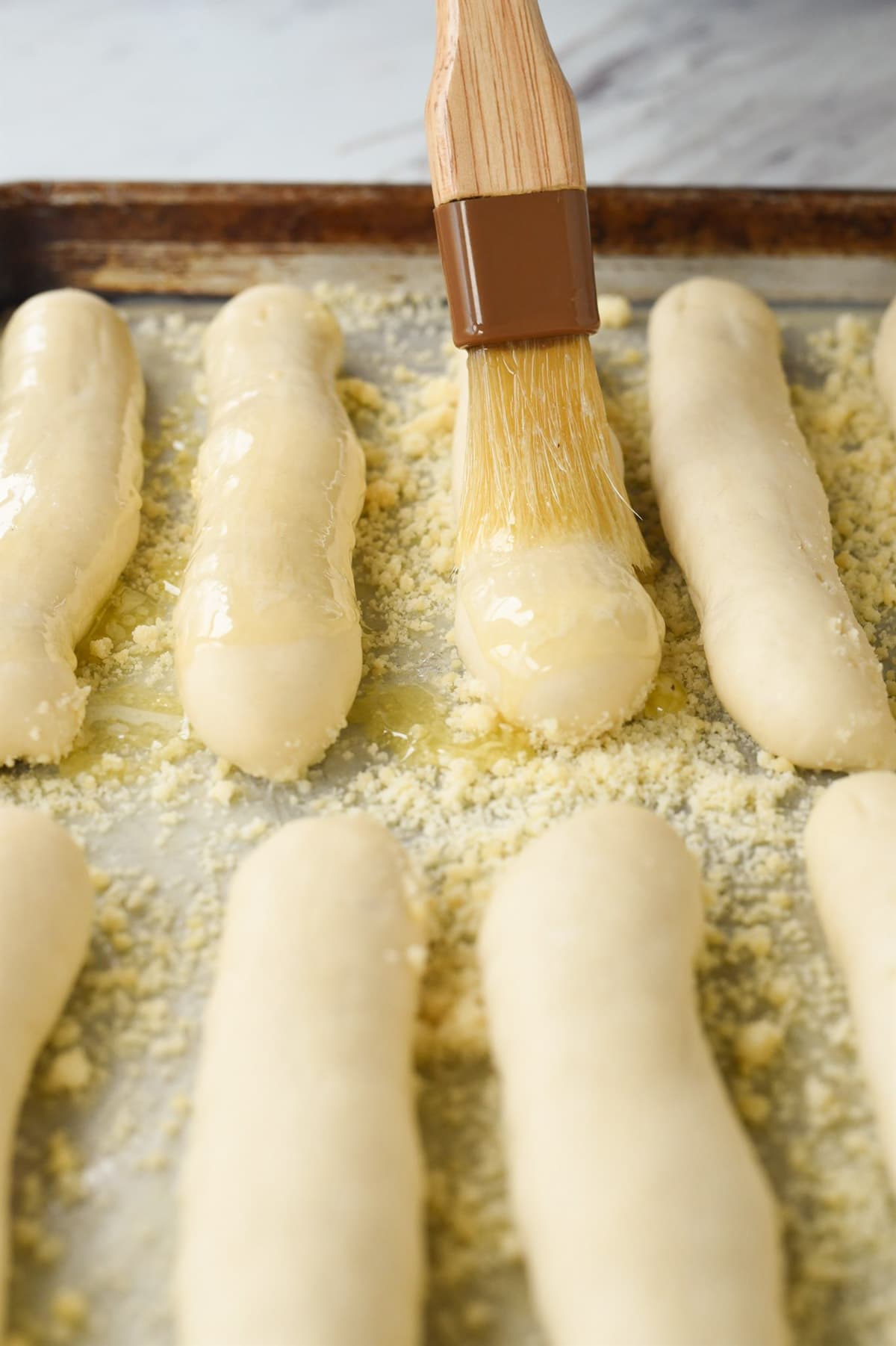 brushing butter on breadsticks