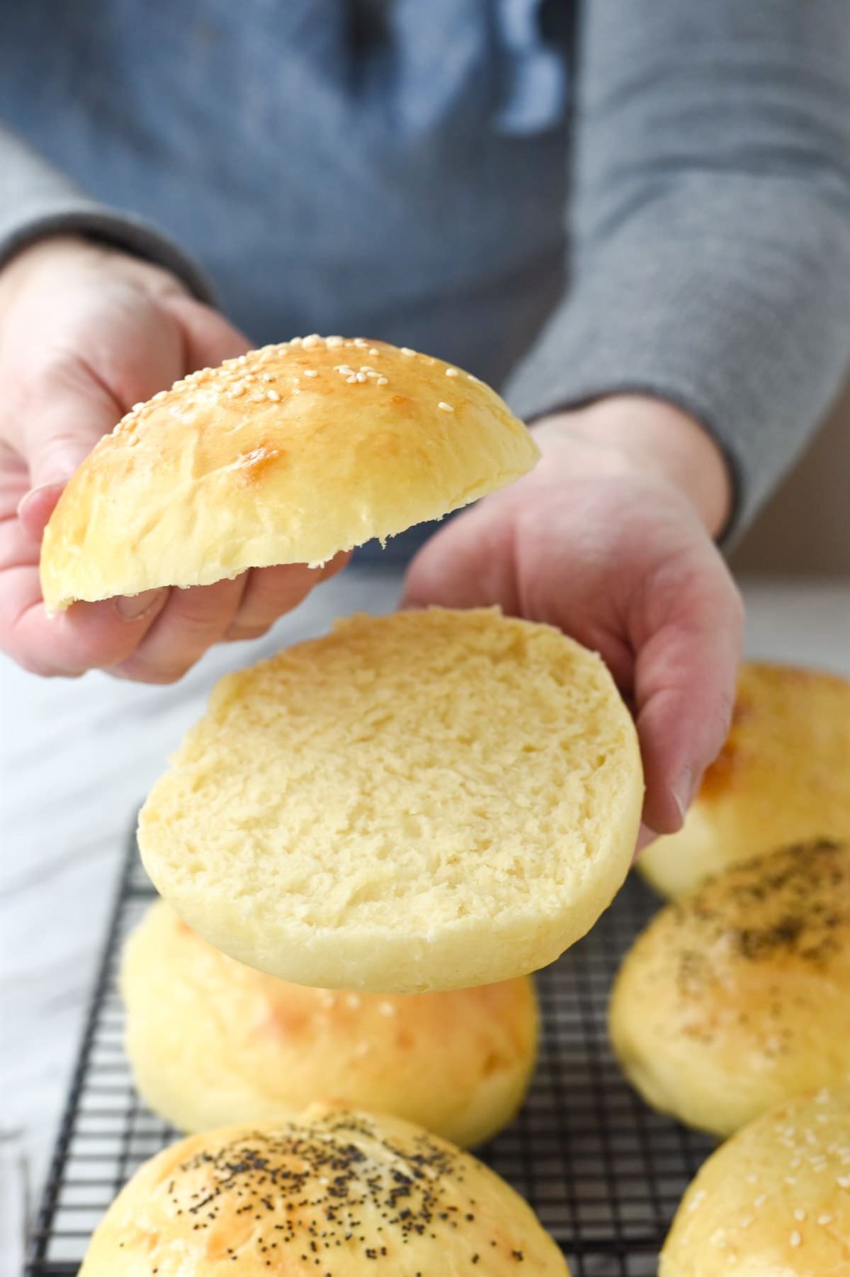 hands holding a sliced hamburger bun