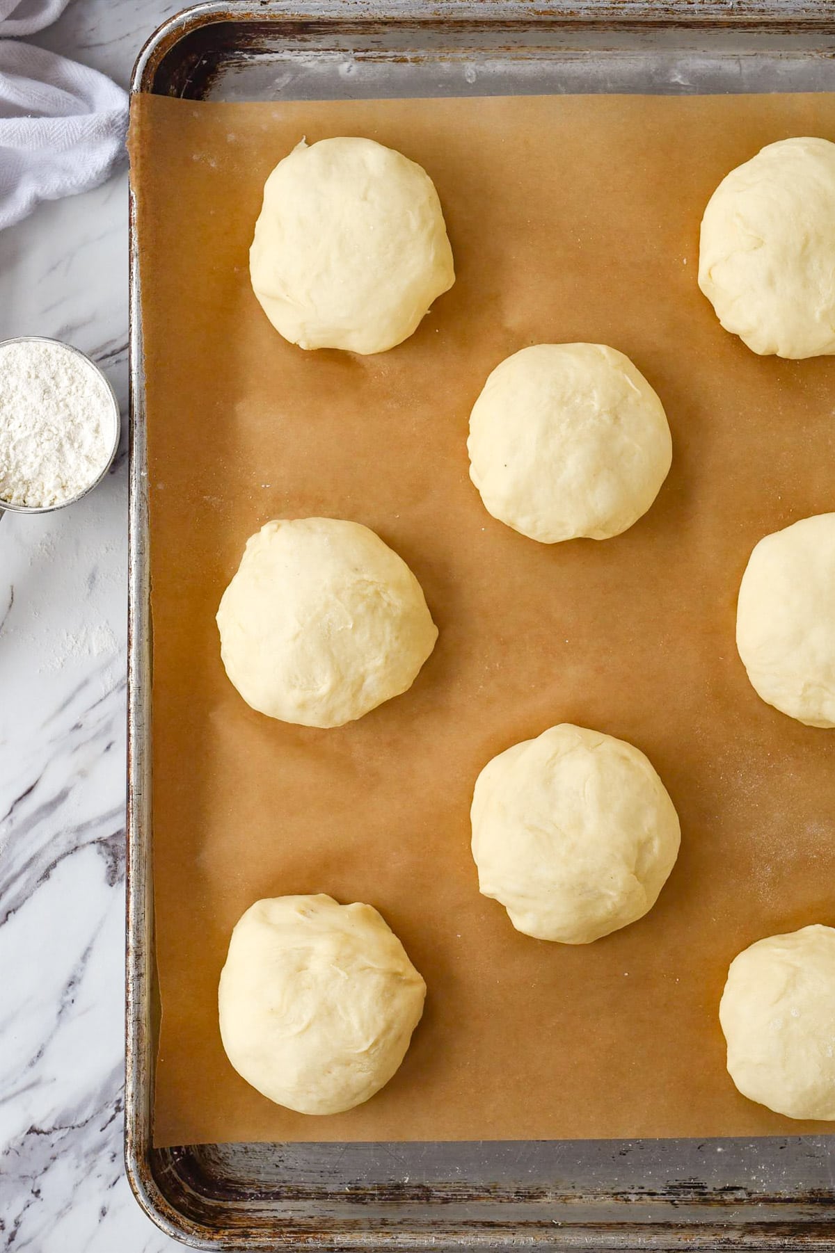 hamburger bun dough on baking sheet