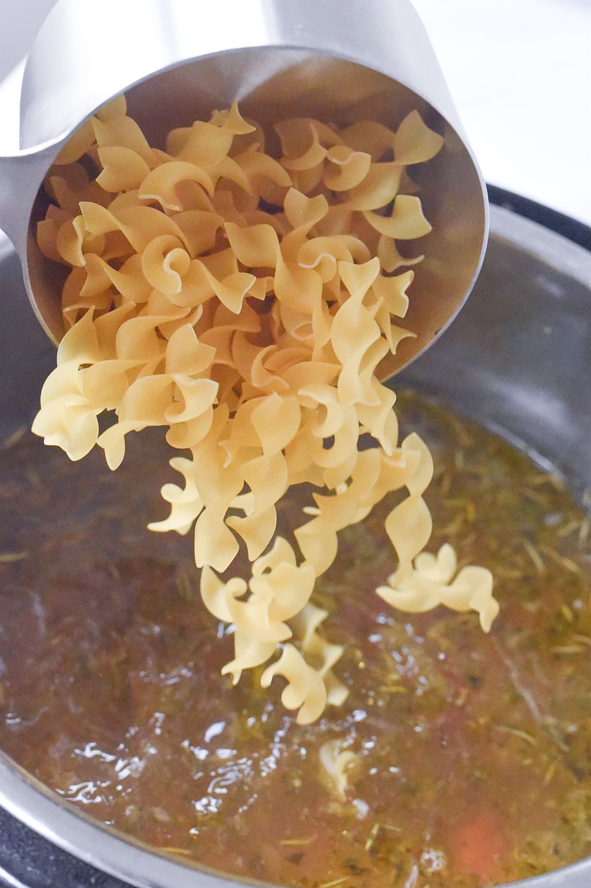 adding noodles to chicken noodle soup