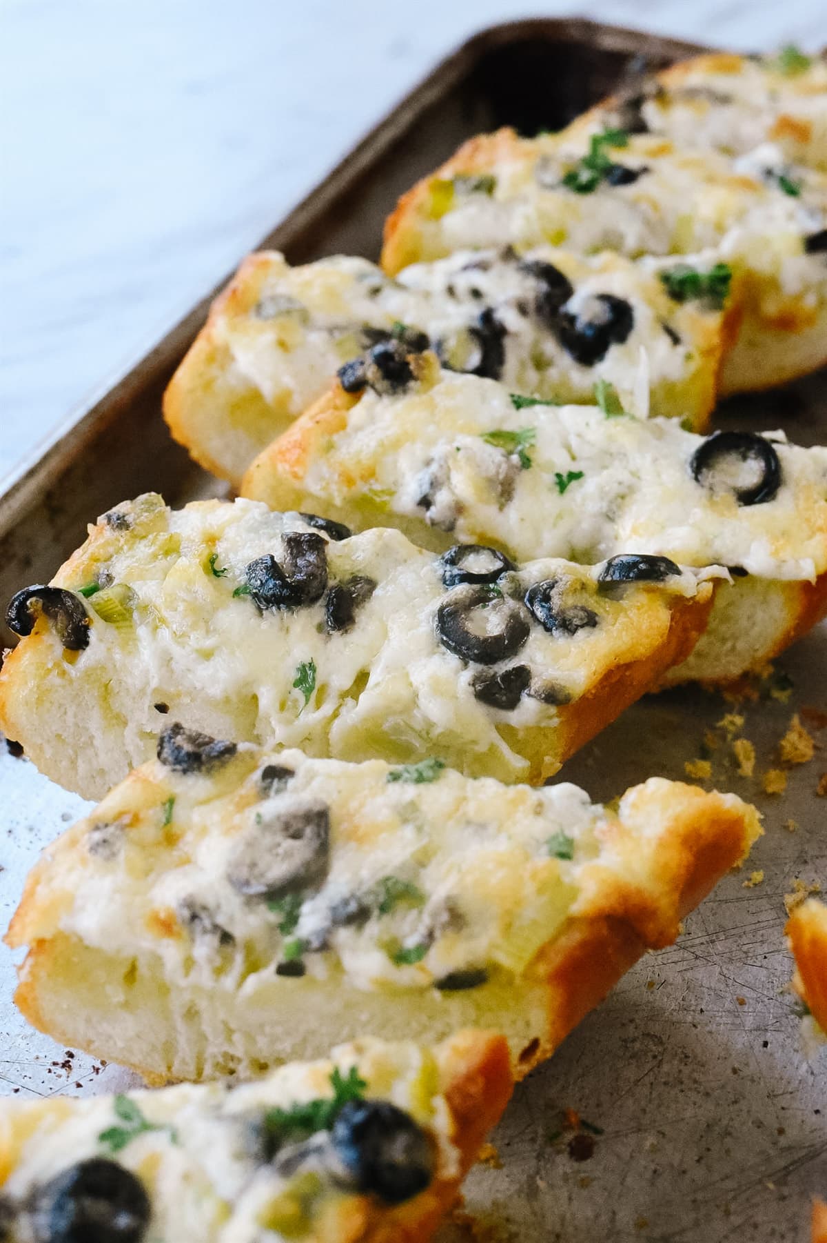 olive bread sliced on a baking sheet