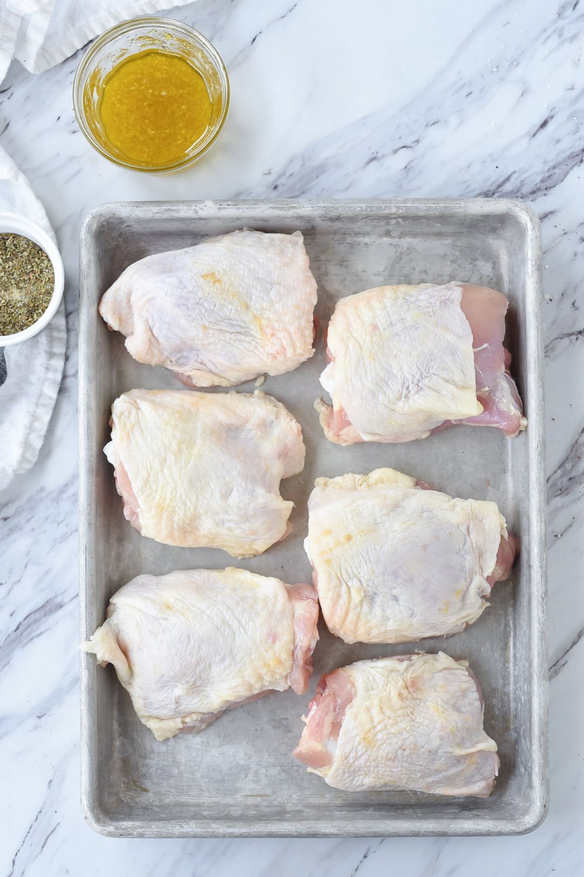 six chicken thighs on a baking sheet