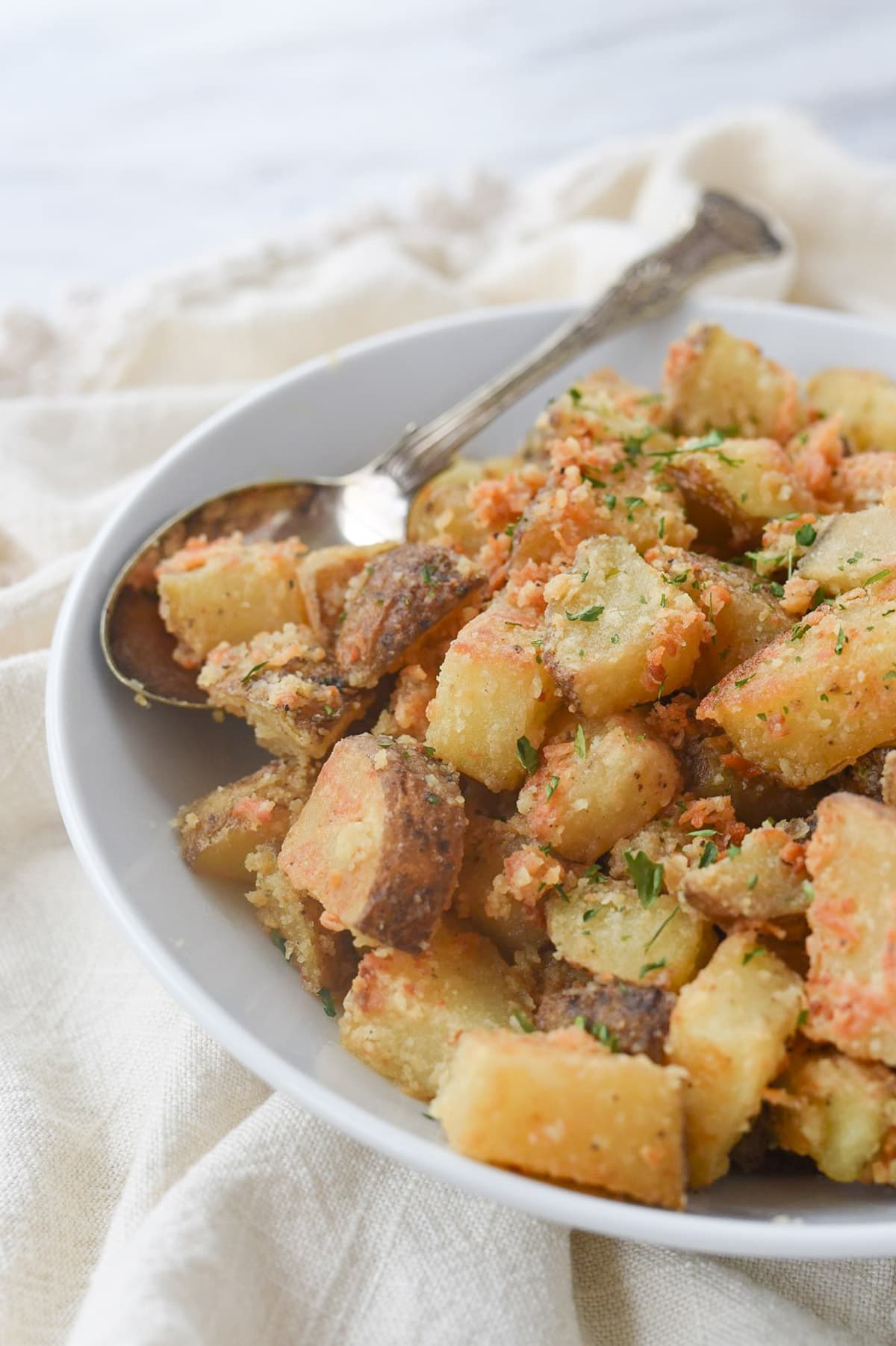 white bowl full of parmesan roasted potatoes