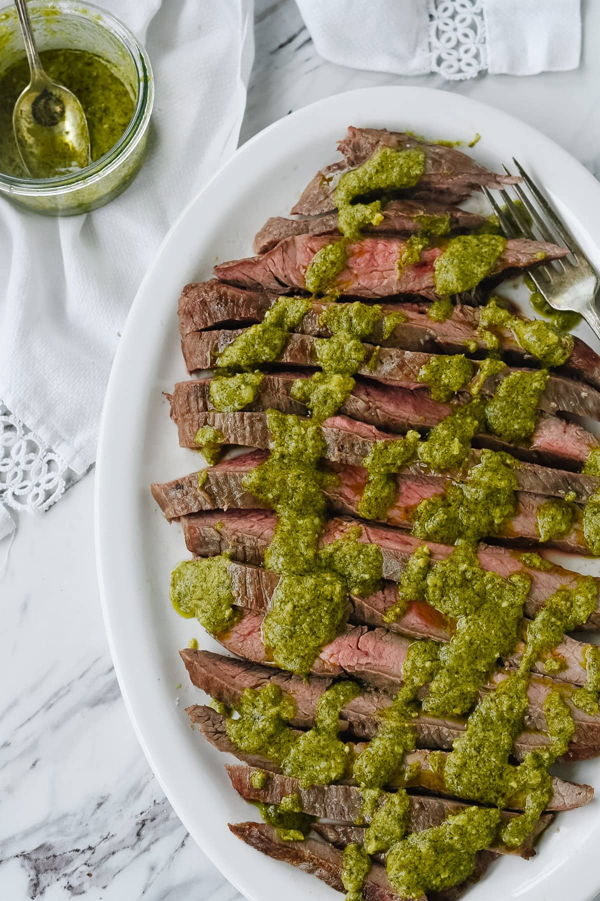 pesto flank steak on a white dish