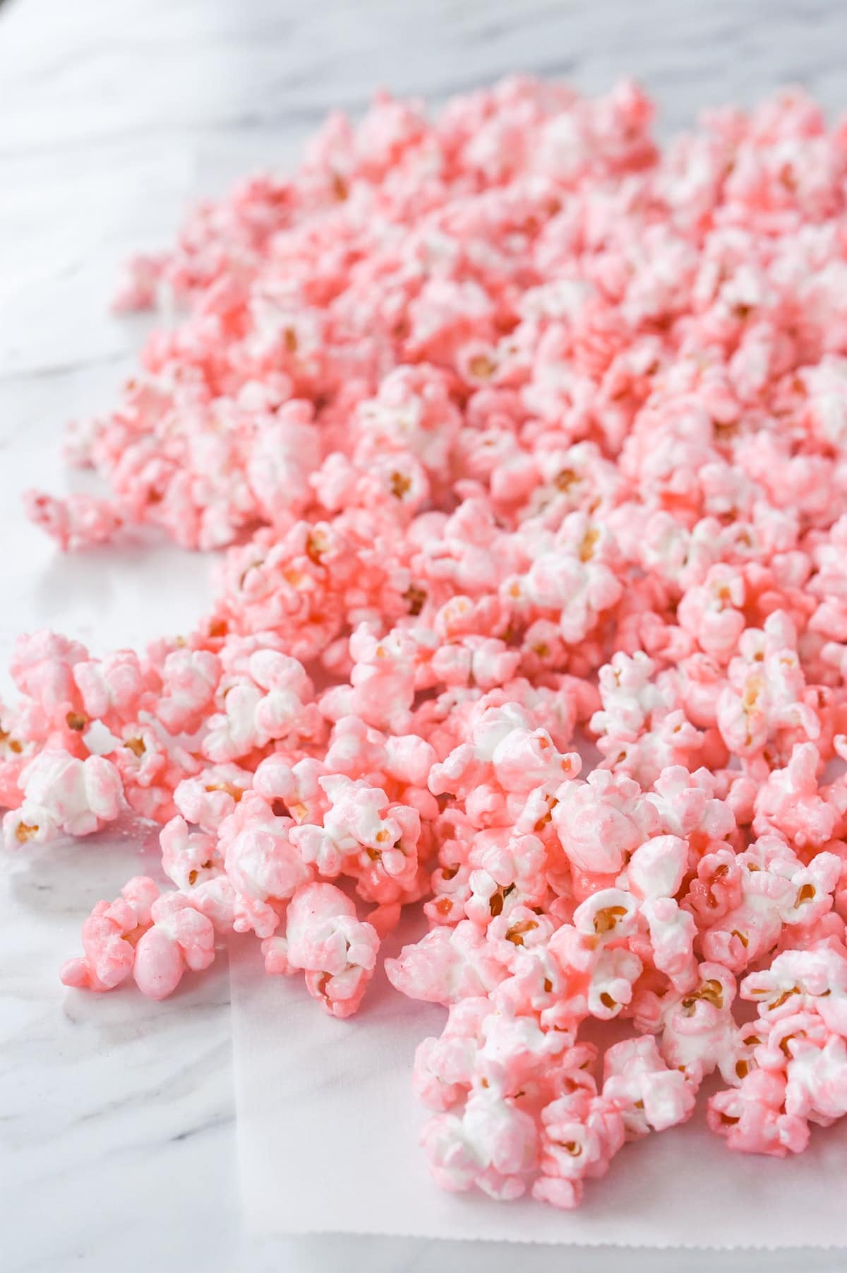 pink popcorn spread out on wax paper