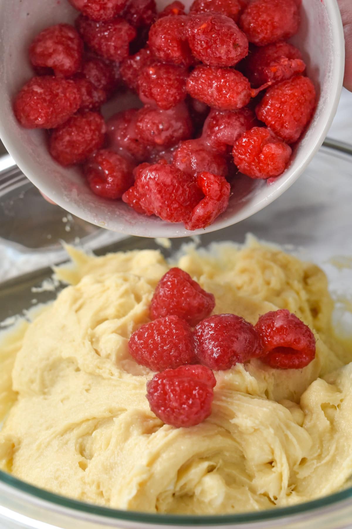 adding raspberries to muffins