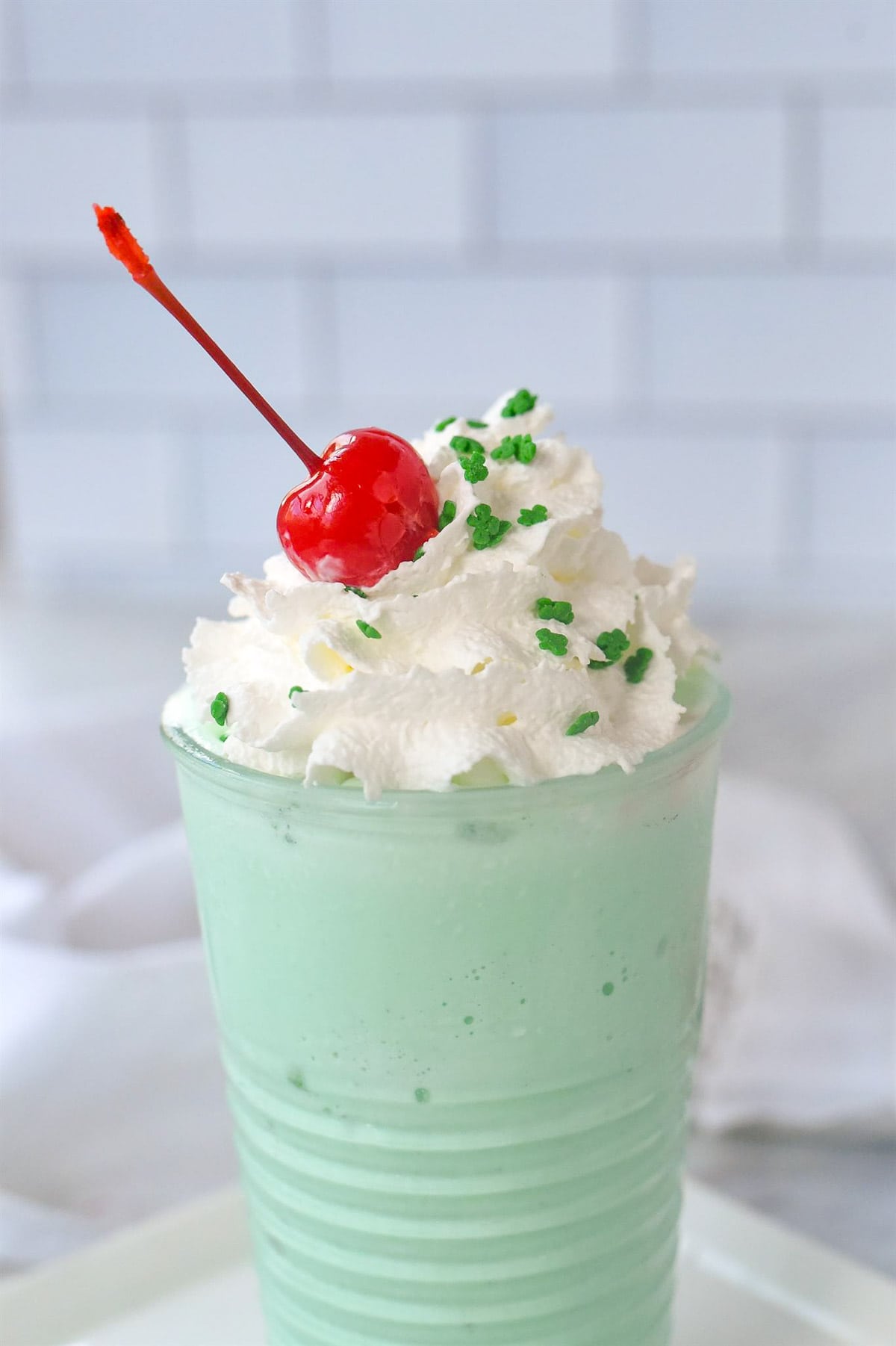 close up of shamrock shake with cherry on top