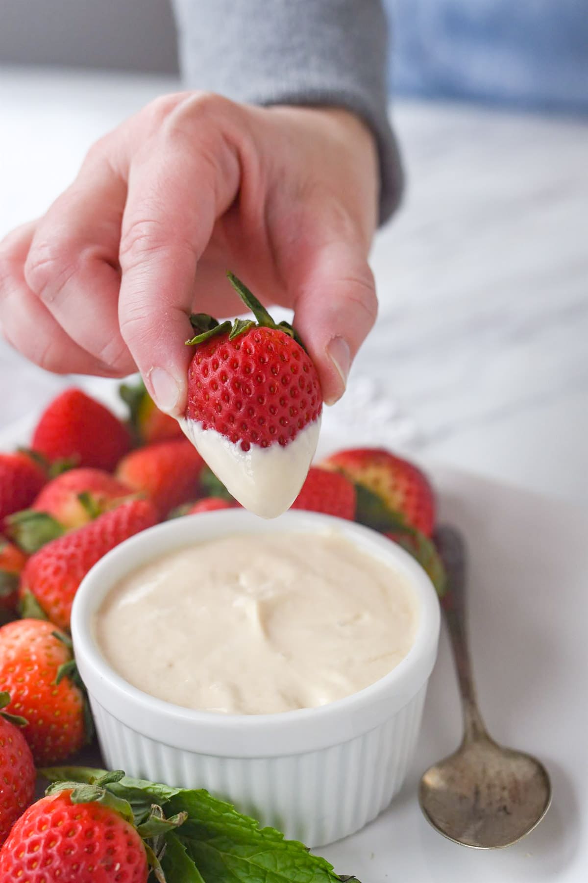 dipping a strawberry in brown sugar sour cream