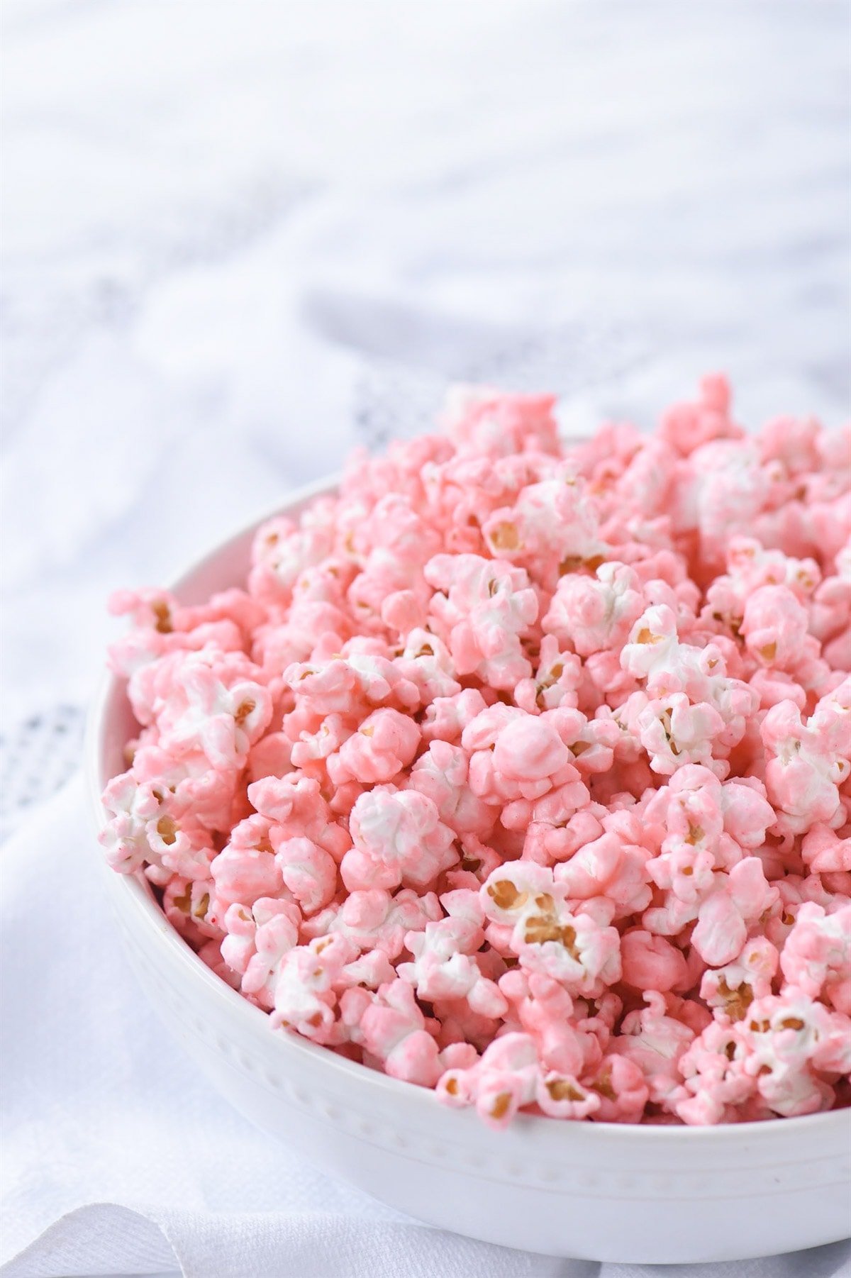 white bowl of pink popcorn