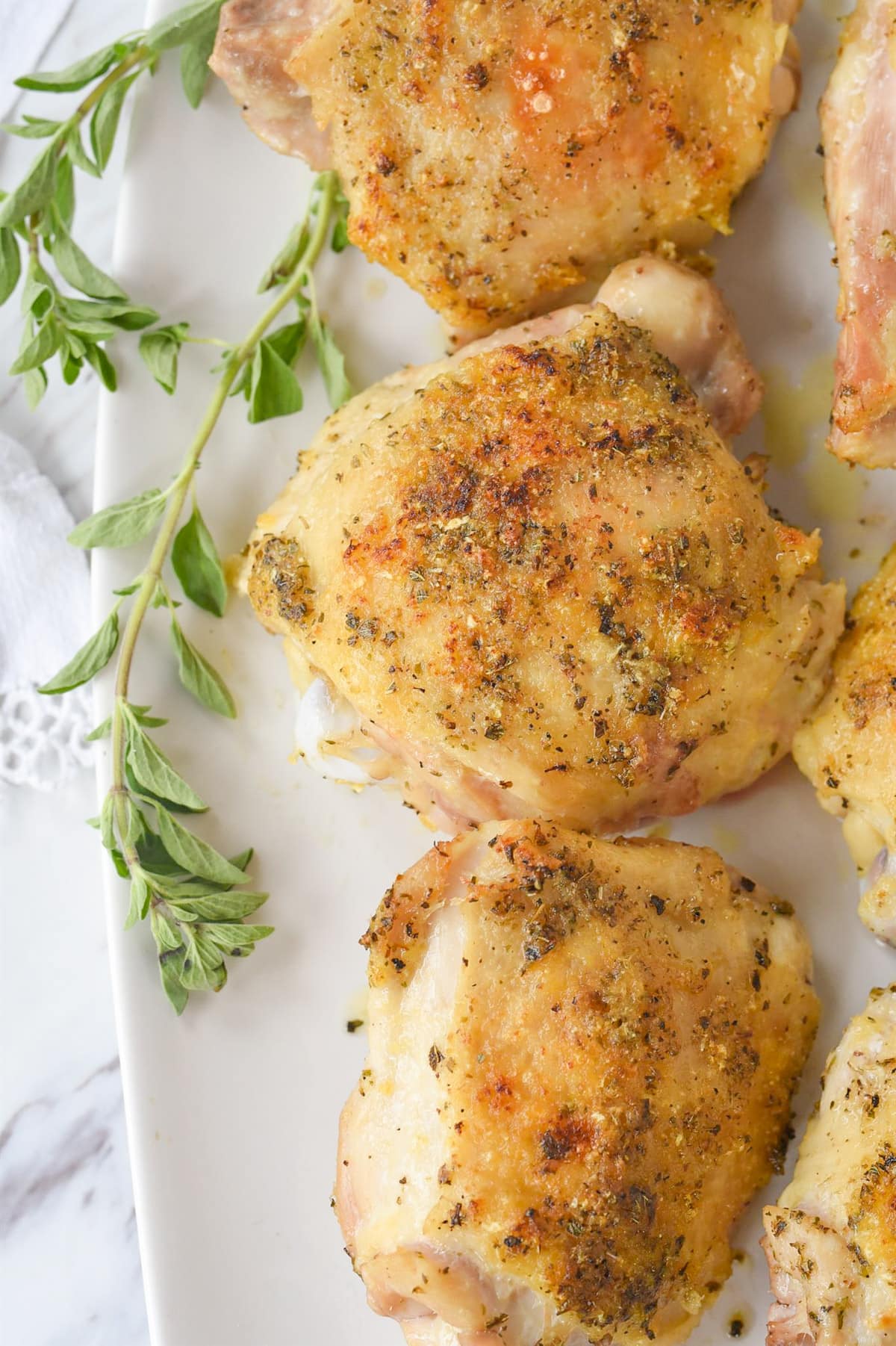 3 chicken thighs on a white plate