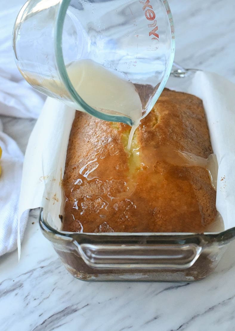 pouring glaze over lemon bread