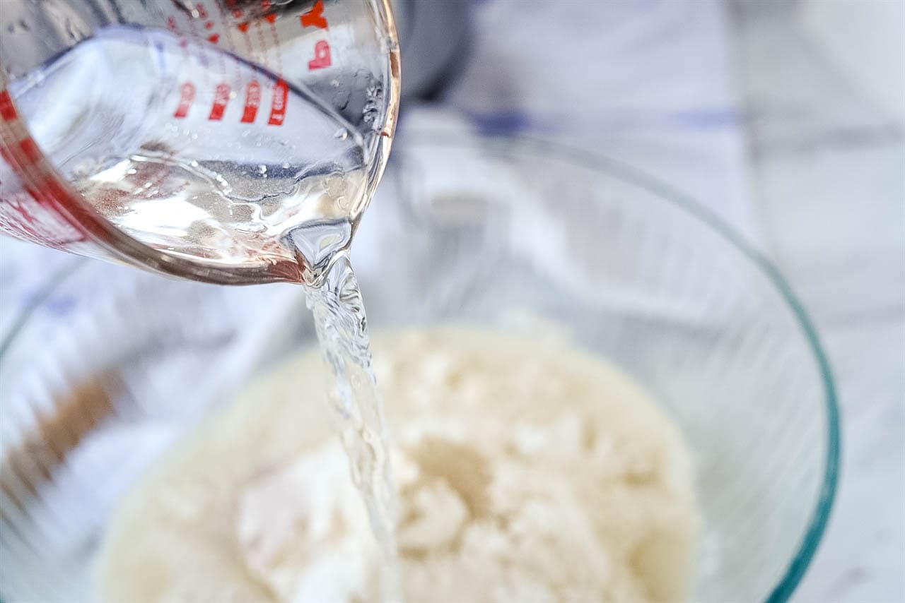 pouring water over bread ingredients