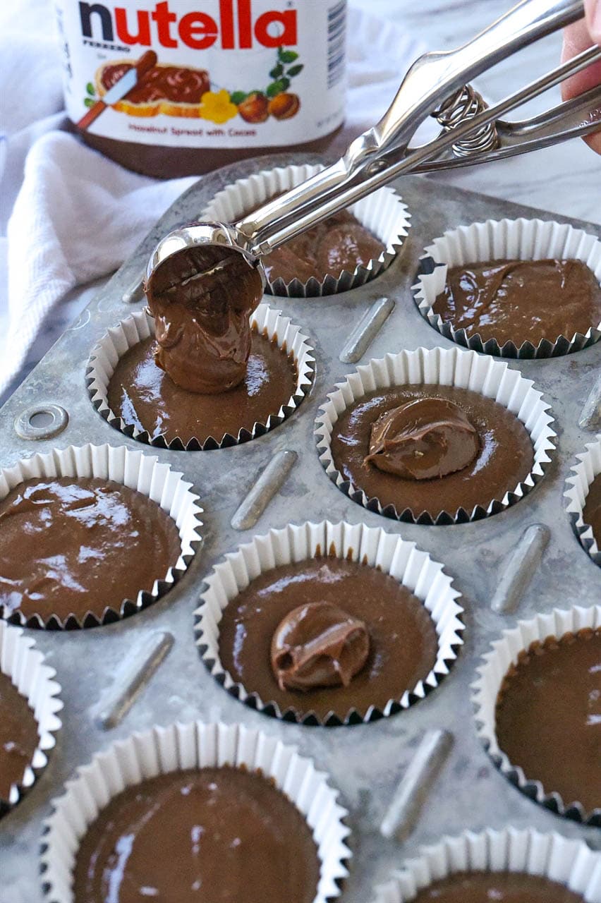 scooping nutella into cupcake