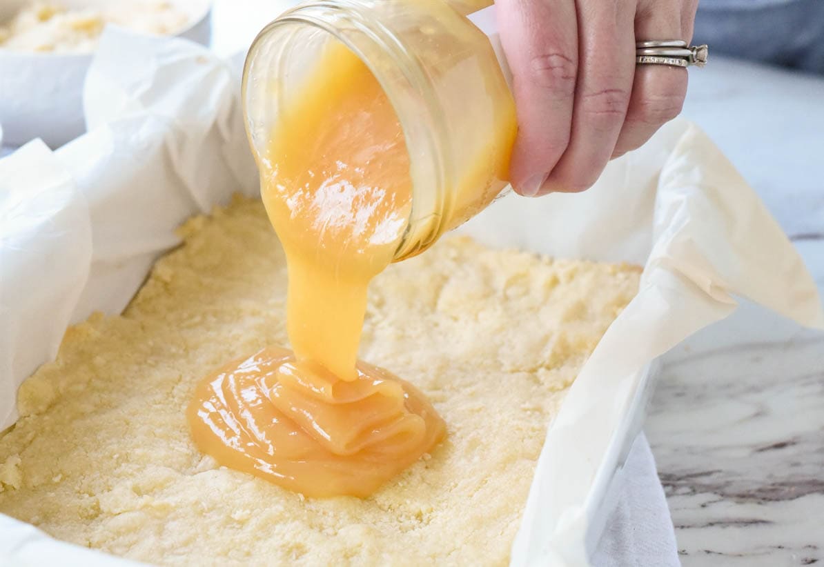 pouring lemon curd on crust