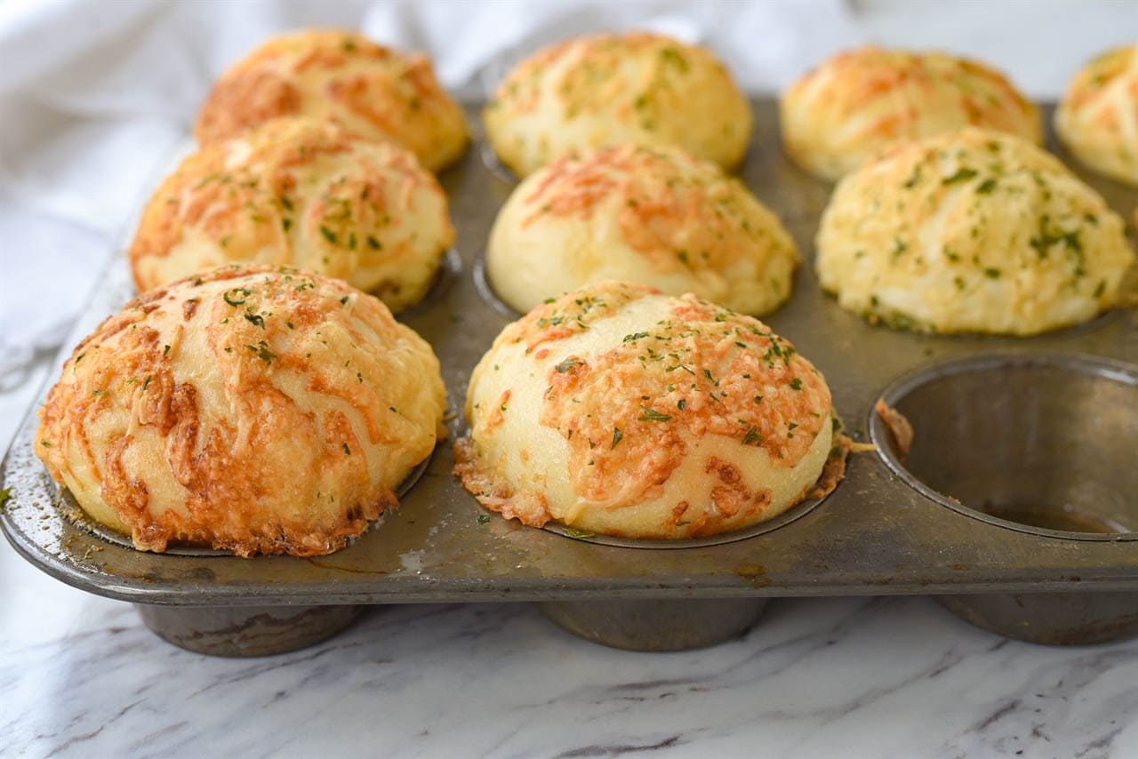 garlic parmesan rolls in a muffin tin