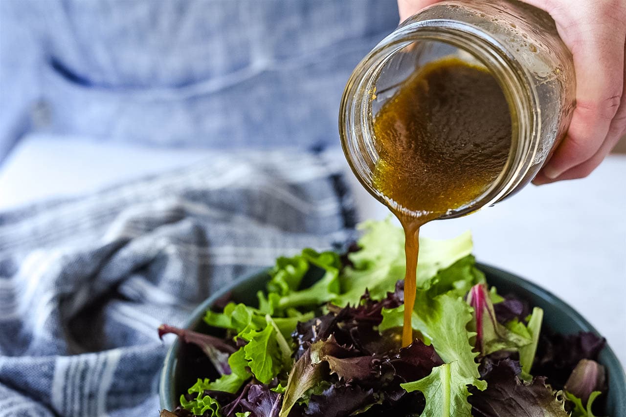 pouring dressing on salad