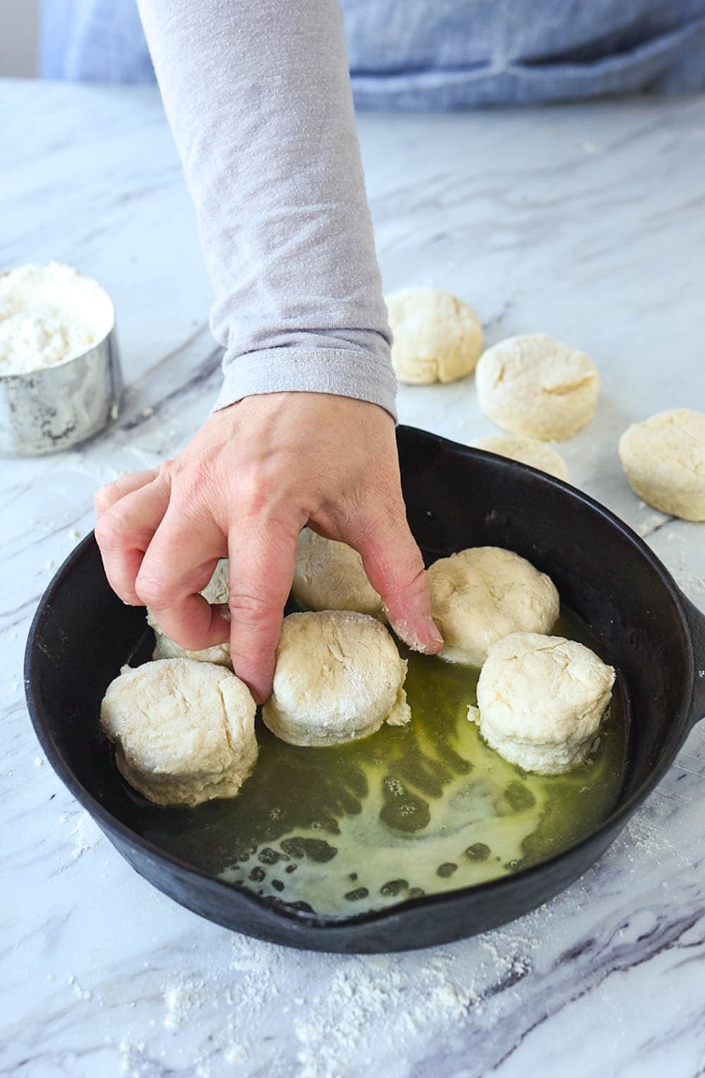 placing biscuits in cast iron pan