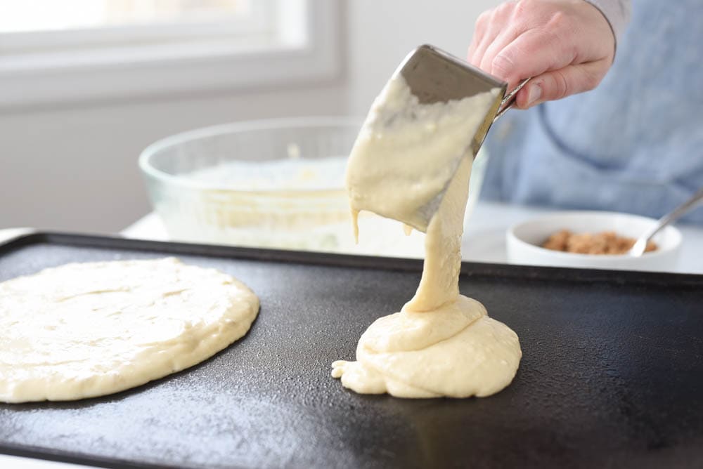 pouring pancake batter onto griddle