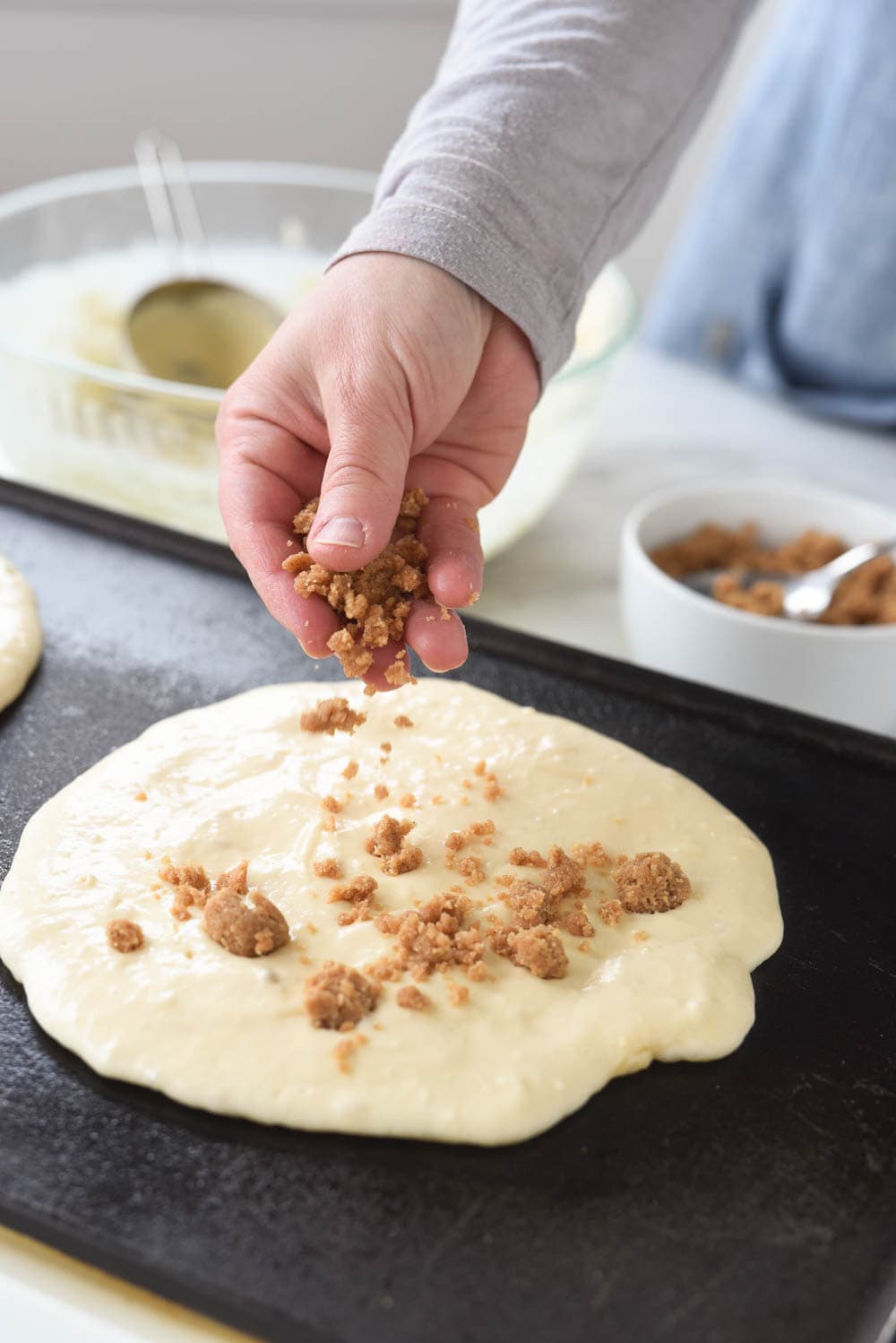 sprinkling streusel topping onto pancake