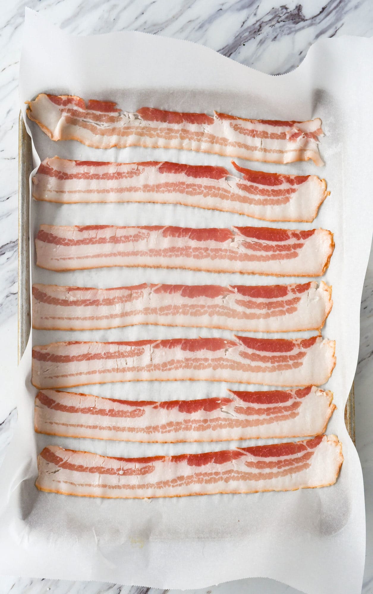 raw bacon on parchment paper