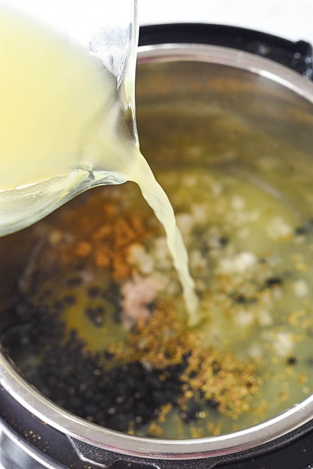 pouring chicken broth into instant pot