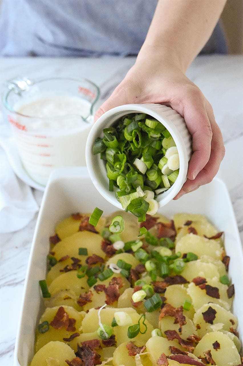 sprinkling green onions on potatoes