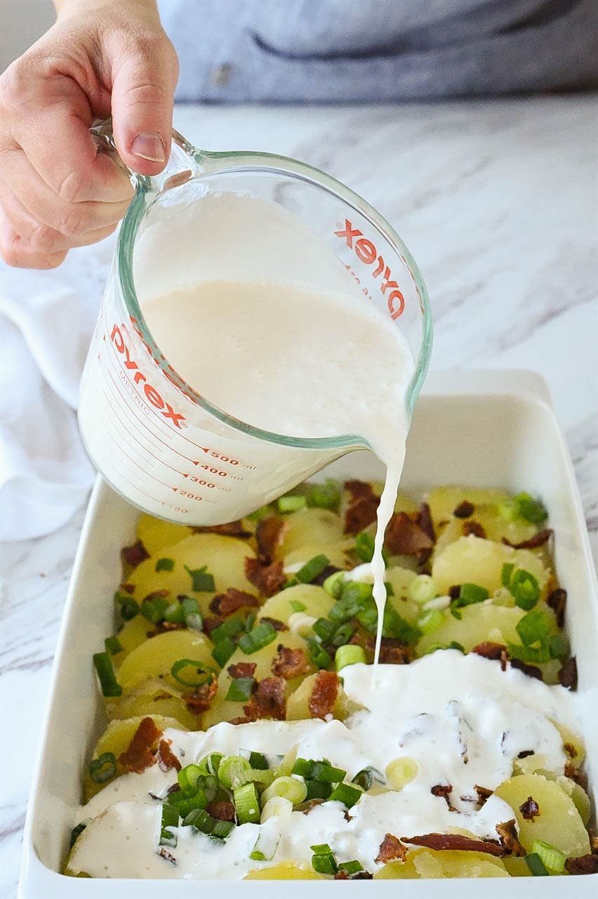 pouring milk over potatoes