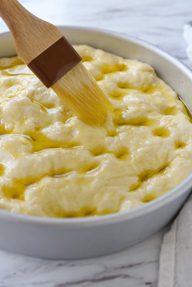 brushing oil on focaccia bread