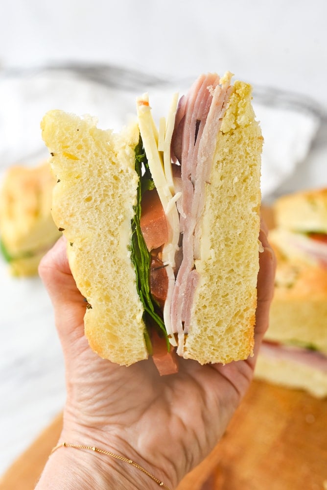 hand holding a piece of picnic sandwich